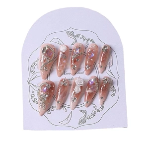 Handmade almond press-on nails with pink gradient, white roses, and 3D floral crystals