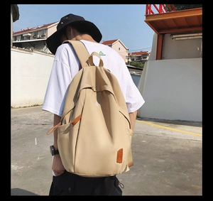 Outdoor shot of the khaki canvas backpack featuring side pockets and durable straps