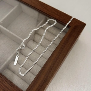 Close-up of S925 sterling silver curb chain necklace detail on a velvet jewelry box