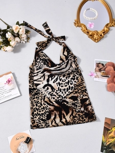 Plano detalle de top halter con estampado de leopardo y accesorios vintage en gris