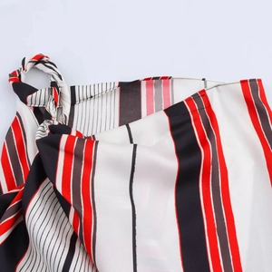 Detail view of the colorful striped fabric and decorative tie knot on the asymmetrical skirt