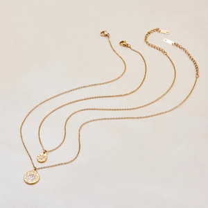 Detail of 18K gold stainless steel double chain with sunburst pendants and white zircon