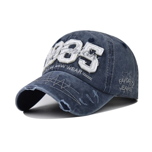 Close-up of vintage 1985 embroidery and distressed denim brim on a baseball cap