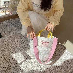 Détail du sac seau matelassé avec imprimés fleurs lapin et large bandoulière réglable