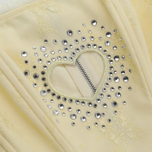 Détail de la découpe en cœur avec strass argentés et fermeture éclair sur haut jaune