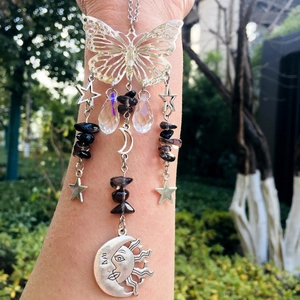 Detail of silver suncatcher with crystal drops, butterfly frame and moon pendant