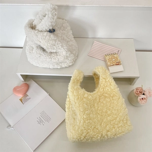 Close-up of soft plush tote bags in white and yellow colors for autumn winter fashion