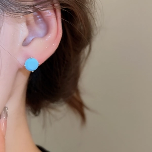 Close-up of model wearing sky blue zircon round stud earring with silver four-prong setting
