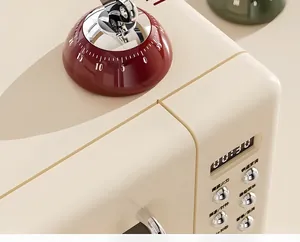 Detail of cream retro microwave with magnetic timer, digital display and metal buttons