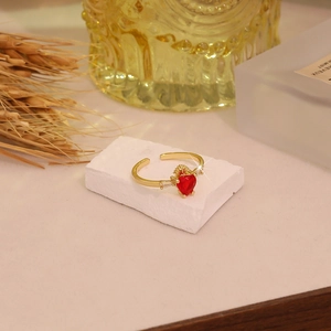 Elegant gold crown open ring featuring a red heart stone and sparkling accents