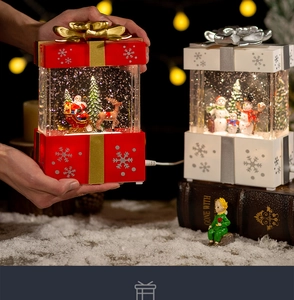 Close-up of Santa and Snowman crystal ball music boxes with warm ambient lighting