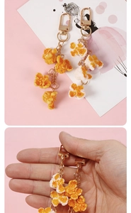 Detail view of realistic PVC popcorn pendants with gold D-rings and metallic chains