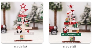 Detail of wooden Christmas tree tabletop ornaments with painted gnome and holiday greetings