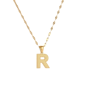 Detail of golden stainless steel necklace featuring a textured letter R pendant on a flat chain