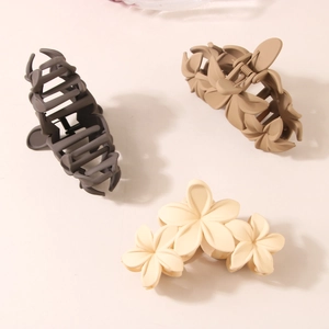Three matte floral and bone-shaped hair claws in dark grey, beige, and cream white colors