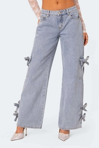 Detail of light blue denim cargo pants with bow tie accents and utility side pockets