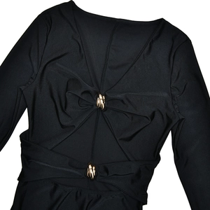 Detail eines eleganten schwarzen V-Ausschnitt-Kleids mit Ausschnitten und Goldschnallen