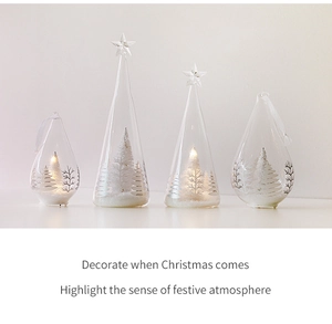 Detailed view of LED lighted clear glass Christmas trees with miniature snowy trees inside