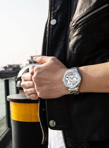 Montre squelette pour homme en acier argenté avec engrenages portés sur une veste en cuir
