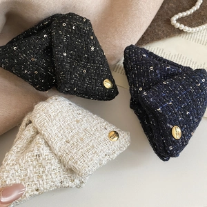 Detailed close-up of tweed shark hair clips with sequins and engraved golden metal charms