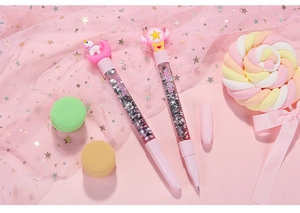 Close-up of pink unicorn and magic wand pens with sparkling silver glitter inside