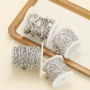 Stainless steel geometric chain set with diverse links on white plastic spools for DIY jewelry