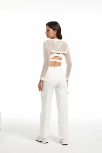 Rear view of white wide-leg cargo pants with pockets and mesh top for a sporty look