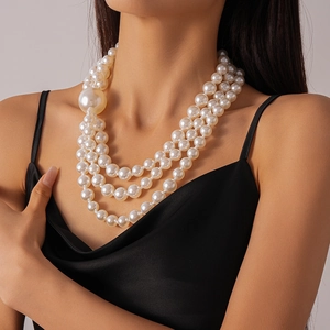 Detail of layered imitation pearl necklace featuring multi-size beads on a model's neck