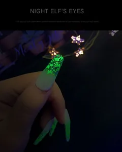 Macro detail of glow-in-the-dark stiletto nails with neon green butterfly and star sequins