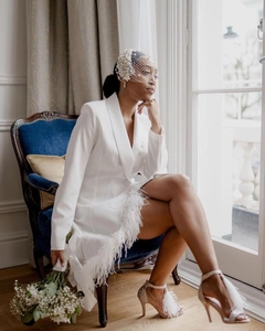 Close-up of white blazer dress with ostrich feather trim and pearl mesh veil detail