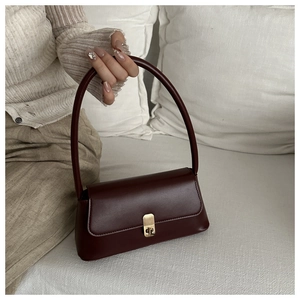 Detail of burgundy PU leather baguette bag with a premium gold-tone square metal lock clasp