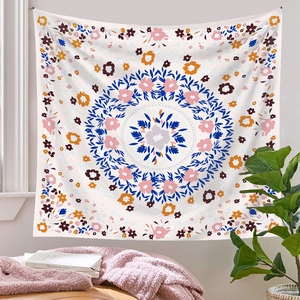 Bohemian style tapestry detail with floral mandala pattern on a beige wall background
