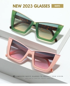 Detail view of cat-eye sunglasses with green tortoise and pink frames on white podium
