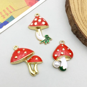 Three red mushroom alloy pendants with gold trim, featuring green leaf and pearl details