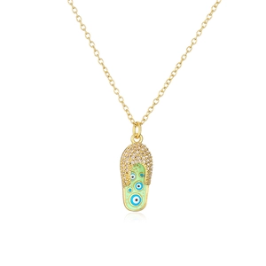 Nahaufnahme der 18K vergoldeten Kette mit grünem Evil Eye Pantoffel-Anhänger und Zirkonia