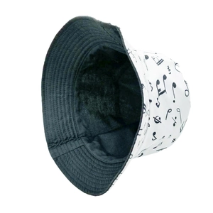 Detail view of double-sided bucket hat with white musical notes print and black cotton lining