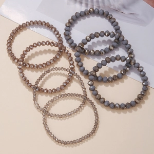 Detail von facettierten Glasperlenarmbändern in Grau- und Bronzetönen mit Gummizug