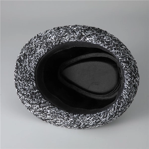 Top down view of vintage tweed fedora hat showing textured grey fabric and black lining