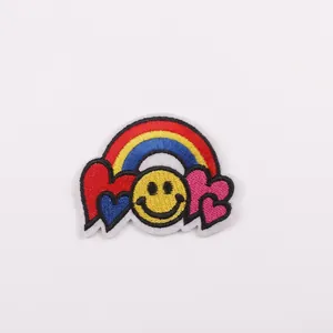 Macro shot of embroidered rainbow patch with smiley face and colorful hearts