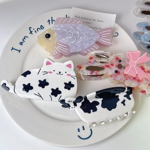 Cute animal acetate hair claws featuring cat, cow and rabbit designs in ceramic plate