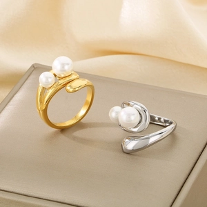 Detailed view of adjustable gold and silver rings with twin pearls on silk background