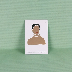 Close-up of paper jewelry display card featuring an abstract female illustration design