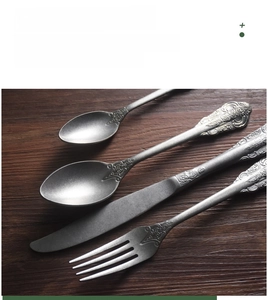 Detail of vintage 304 stainless steel cutlery with baroque embossed pattern handles
