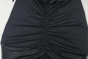 Nahaufnahme von schwarzem Mesh-Gewebe mit gerafftem und gefaltetem Design am Kleid