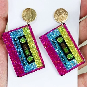 Close-up of retro 90's cassette tape earrings with colorful glitter acrylic finish