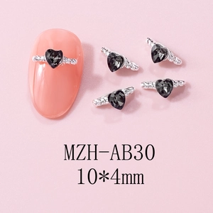 Macro shot of 10x4mm heart-shaped nail charms with black rhinestones and silver wings