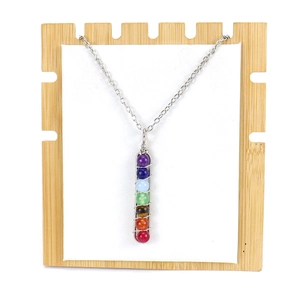 Handmade silver wire wrapped 7 chakras beads pendant necklace on a wooden display stand