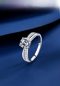 Macro shot of 1ct moissanite ring with four-prong setting on cross-open silver band