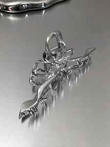 Close-up of a silver liquid metal butterfly hair claw clip with mirror finish and hollow design