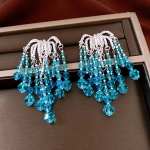 Detail of vintage silver needle earrings with blue gradient crystal glass tassels